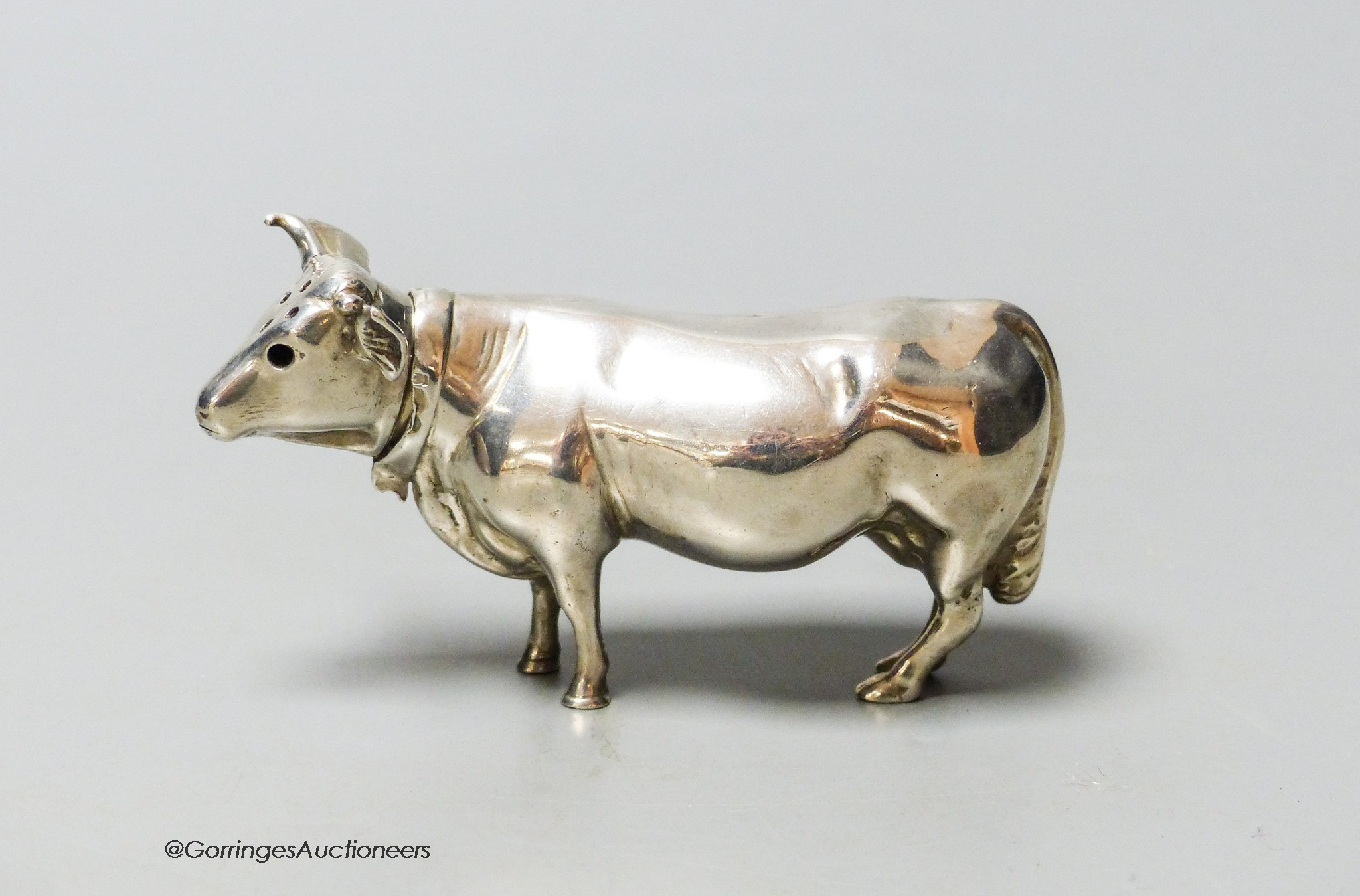 An Edwardian Hanau silver novelty silver pepper pot, modelled as a cow, Chester import marks for Berthold Muller, 1905, length 9cm, 62 grams.